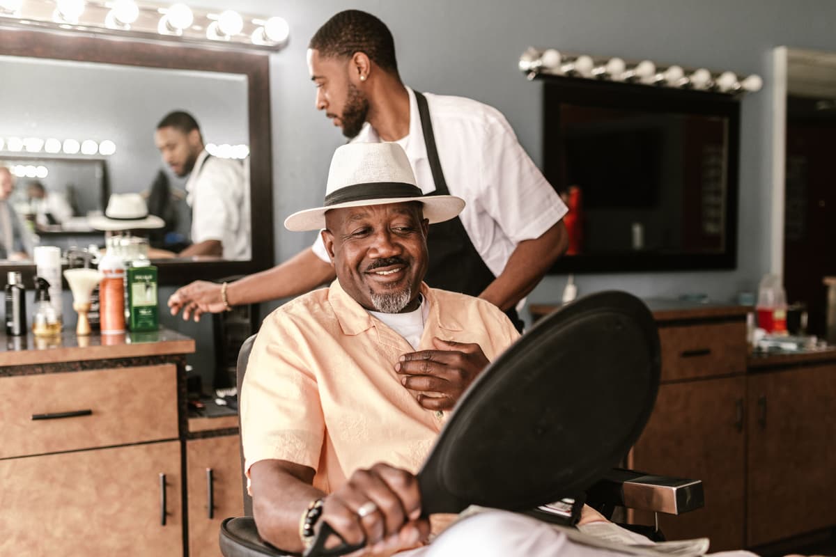 Client smiling while looking at her new haircut in the salon mirror